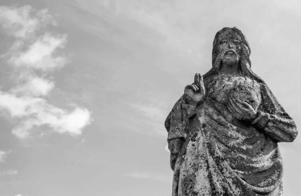 Very old stone statue of Jesus Christ. Black and white image. Faith, religion, death, resurrection concept.