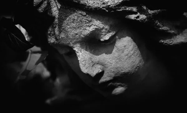 Death. Ancient statue of sad angel of death as symbol of human pain, fear and end of life.Black and white image.