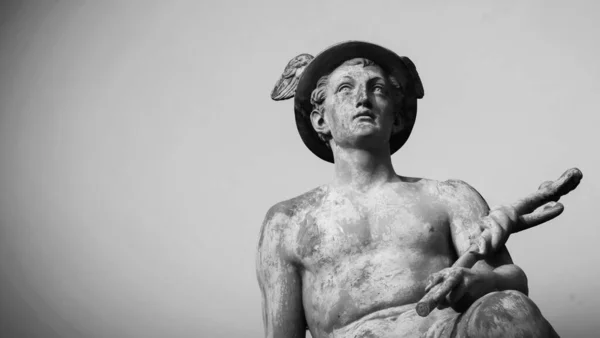 An ancient statue of antique god of commerce, business, merchants and travelers Hermes (Mercury). Copy space for text. Black and white image.
