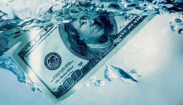 Global financiall crisis concept. Dramatic image of US Dollar sinking in water