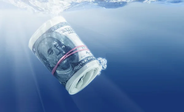 Conceptuall image of US Dollar sinking in water as symbol of global financiall crisis.