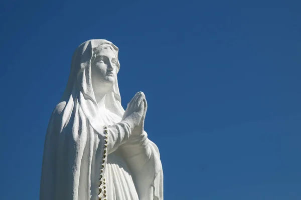 Valkoinen Neitsyt Marian Patsas Rukoilee Sinistä Taivasta Vastaan Kopioi Tila — kuvapankkivalokuva