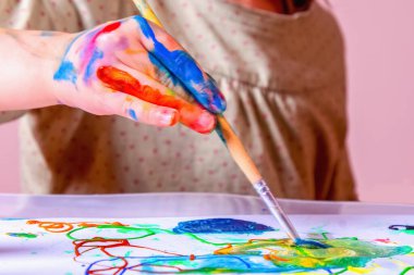 Selamlama sanatçısının komik bir görüntüsü. Fırçayla resim yapan genç ve güzel bir kız. Sanat, çocukluk, öğrenme ve yaratıcılık kavramı. Yatay resim.