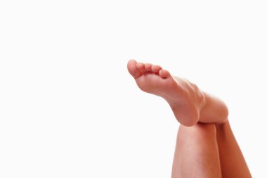 Dinlenmenin, uyumanın ve rahatlamanın sembolü olarak beyaz arka plana karşı insan bacakları. Metin veya tasarım için boşluk kopyala.