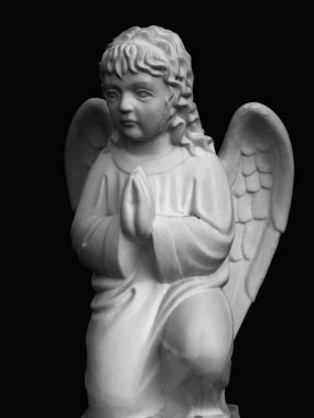 Siyah arka plana karşı beyaz küçük bir melek. Siyah ve beyaz resim.