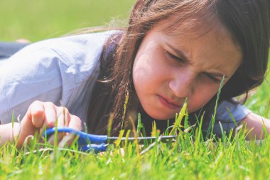 Kavramsal görüntü: Obsesif-kompulsif bozukluk (OCD), bir kişinin psikolojik ve zihinsel sorunları. Genç güzel kız çimleri makasla kesiyor ve mükemmel bir şekilde dengelemeye çalışıyor. Yatay resim.