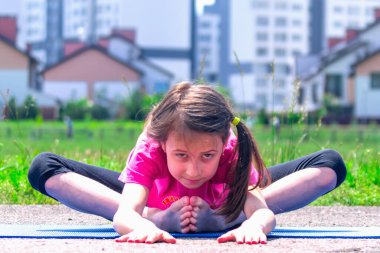Genç sportif çekici kız dışarıda yoga yapıyor. Sağlıklı yaşam tarzı ve zihinsel sağlık kavramı.