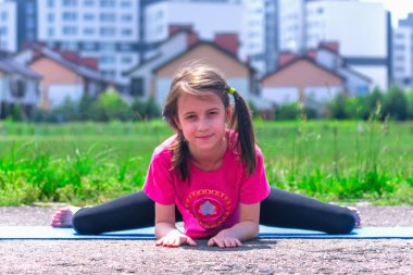 Şehre karşı yoga yapan genç bir kız. Sağlıklı yaşam tarzı ve zihinsel sağlık kavramı.