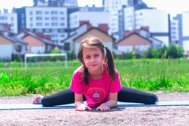 Şehre karşı yoga egzersizi yapan genç ve çekici kızın portresi. Sağlıklı yaşam tarzı ve zihinsel sağlık kavramı.