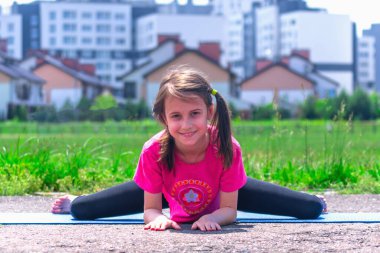 Şehre karşı yoga egzersizi yapan çekici, genç bir kız. Sağlıklı yaşam tarzı ve zihinsel sağlık kavramı.