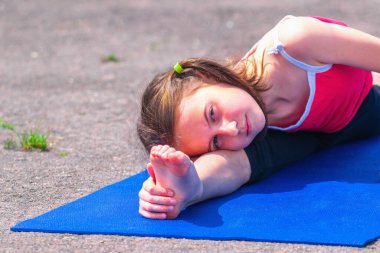 Ayağımı uzatıyorum. Genç sportif çekici kız dışarıda sicim kırıyor. Spor, sağlıklı yaşam tarzı ve eğlence anlayışı. Tasarım veya metin için boşluk kopyala.