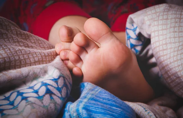 stock image Little child girl sleeping in bed. Close up feet on a blanket. Horizontal image.