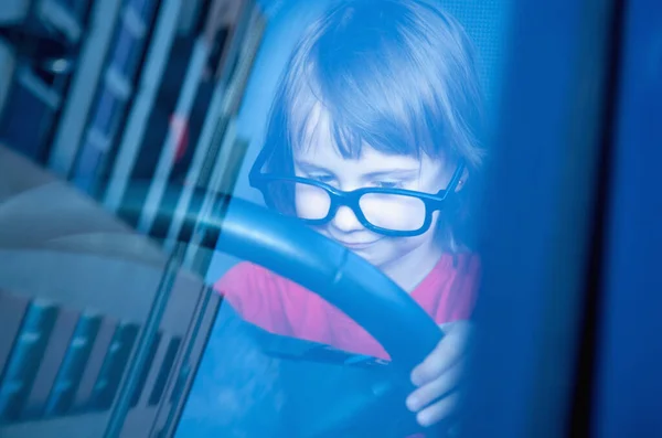 stock image Driving shool. Humorous photo of cute little child girl learns to drive.