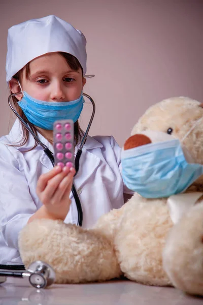 Kleine Schattige Kind Meisje Arts Beschermende Gezichtsmasker Geeft Tabletten Aan — Stockfoto