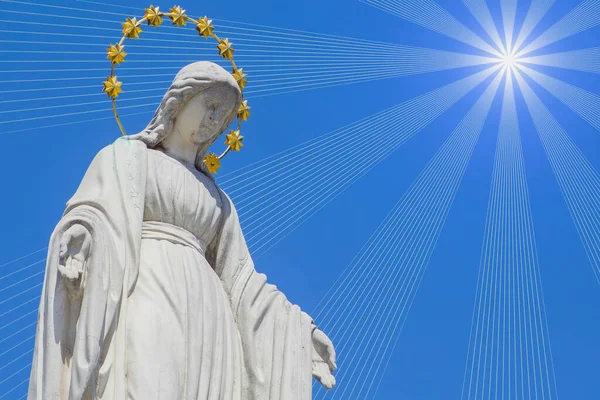聖母マリア天の女王は太陽の光の中で 青空を背景にしたアンティークの像 水平像 — ストック写真