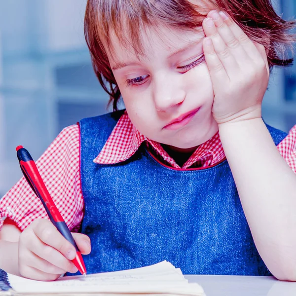 一个可爱的小女孩在学习和做作业的过程中感到悲伤和厌烦的形象 童年和情感概念 — 图库照片