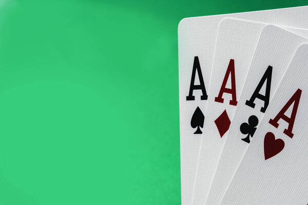 Four aces poker cards against green background. Four of a kind combination in poker game. Poker combinations concept. Copy space.