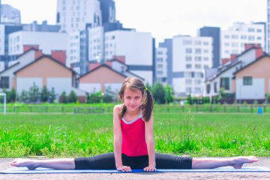 Genç sportif çekici kız ayrılışı yapıyor (spagat). Spor, sağlıklı yaşam tarzı ve eğlence konsepti.