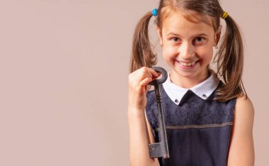 Mutluluğun büyük anahtarını tutan mutlu genç kızın komik psikolojik portresi. Metin veya tasarım için boşluk kopyala.