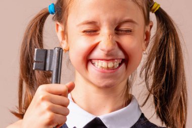 Mutluluğun anahtarı olarak büyük anahtarı tutan çok mutlu genç bir kızın komik psikolojik portresi. Yatay resim.