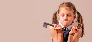 Kafası karışmış genç kızın portresi büyük anahtarı ve küçük kilidi kötü şifrenin, güvenliğin ve şifre yönetiminin sembolü olarak taşıyor. Metin veya tasarım için boşluk kopyala.