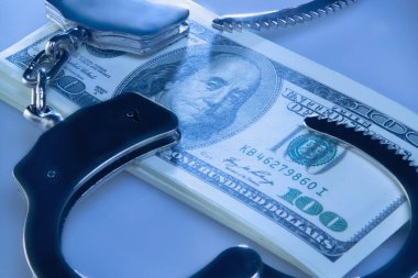 Dolar banknotları, kelepçeler ve yargı sistemindeki yolsuzluğun sembolü olarak hakimin tokmağı. Yatay resim