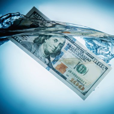 Küresel ekonomik ve finansal kriz. Uluslararası ticaret ve yatırımın belirsiz geleceğinin simgesi olarak suya batan Amerikan Doları banknotlarını kapat. 
