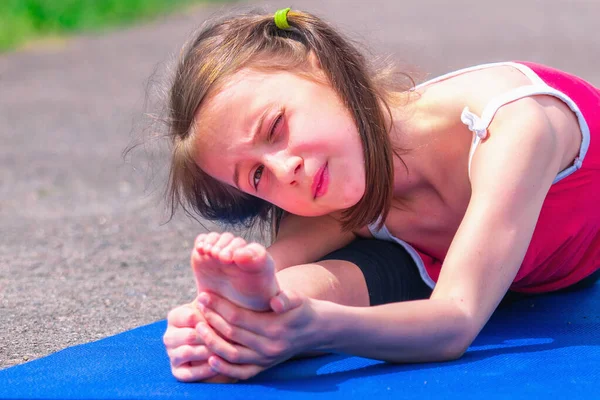Ayağımı uzatıyorum. Genç sportif çekici kız dışarıda sicim kırıyor. Spor, sağlıklı yaşam tarzı ve eğlence anlayışı. Yatay resim.