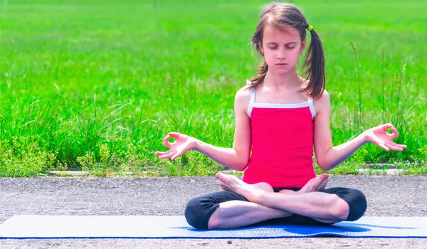 Genç sportif çekici kız yoga dersi alıyor, nefes alıyor, meditasyon yapıyor Ardha Padmasana egzersizi yapıyor, Lotus Mudra hareketleriyle poz veriyor, dışarıda spor yapıyor. Metin veya tasarım için boşluk kopyala.