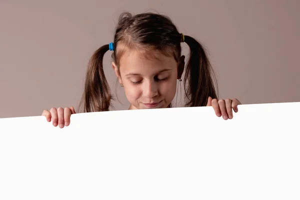 Menina Bonita Olhando Para Baixo Atrás Quadro Branco Vazio Espaço — Fotografia de Stock