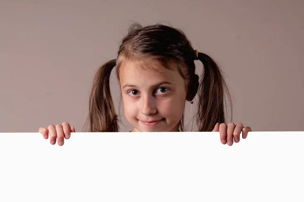 在白色空白横幅或棕色背景的空白复制空间广告板后面 为文字或设计复制空间 是一个快乐迷人的小女孩 横向图像 — 图库照片