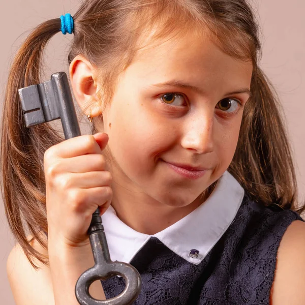 Mutluluğun sembolü olarak elinde büyük bir anahtar tutan çok mutlu genç bir kız.. 