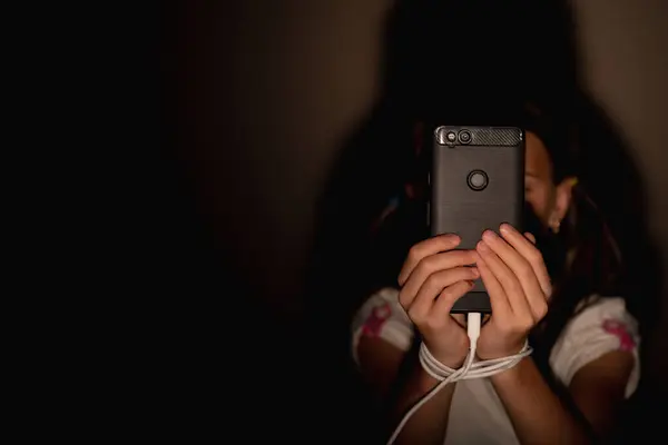 Portrait of young child girl playing smartphones during night time. She is chatting with her friend. Using phone in low light is impact to eyes. Health and gadget addiction concept. Copy space for text.