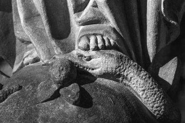 Hıristiyanlığın dini sembolü: Bakire Meryem kötülüğe karşı iyinin zaferinin bir sembolü olarak yılana basar. Antika bir heykel parçası. Siyah ve beyaz resim.