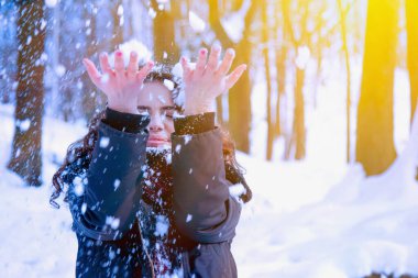 Kar tanesiyle oynayan güzel, mutlu bir genç kadının portresi. Noel, yeni yıl, tatil, eğlence, kış konsepti. Boşluğu kopyala.