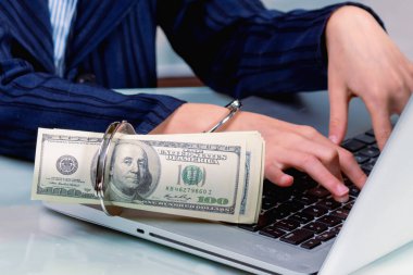 Ofiste dizüstü bilgisayarda çalışan genç bir iş kızı internette para ile kelepçeleniyor. Kapat..