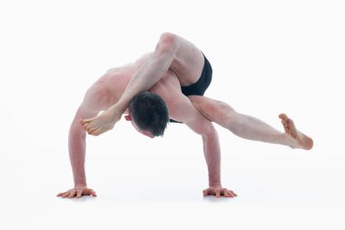 Eka pada sirsasana. Ashtanga yoga adamı spor giysisi giyiyor ve beyaz arka planda yoga egzersizi yapıyor. Yatay resim.