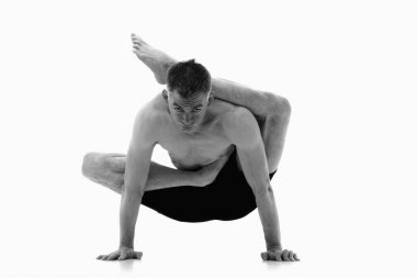 Viranchyasana (Foot behind the head poz), Ashtanga yoga side view of man in sportt giyerek beyaz arka planda Yoga egzersizi yaparken. Siyah ve beyaz resim.