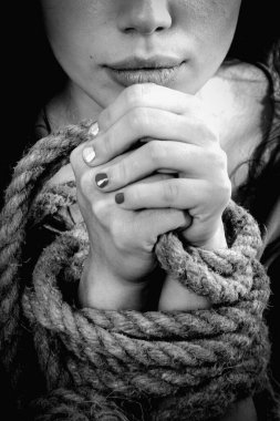 Özgürlük arzusunun sembolü olarak elleri bağlanmış bir kadın. Siyah ve beyaz dikey resim.