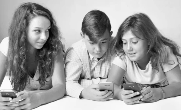 Mobile phones addiction. Group of friends gaming on smart phones. Black and white image.