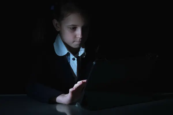 Lack of sleep as a result of studying at night may impair children's mood, increase stress and anxiety levels and decreased cognitive abilities. Young girl studies at night. Black and white image.