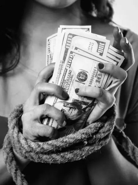 Money is freedom concept. Close up woman\'s hands bound with rope as symbol of lack of opportunities without money. Black and white image.