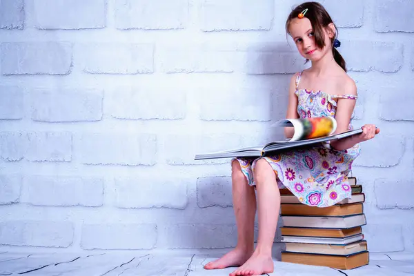 Portrait of beautiful young girl reading the book as symbol of knowledge, learning, development. Copy space for design.