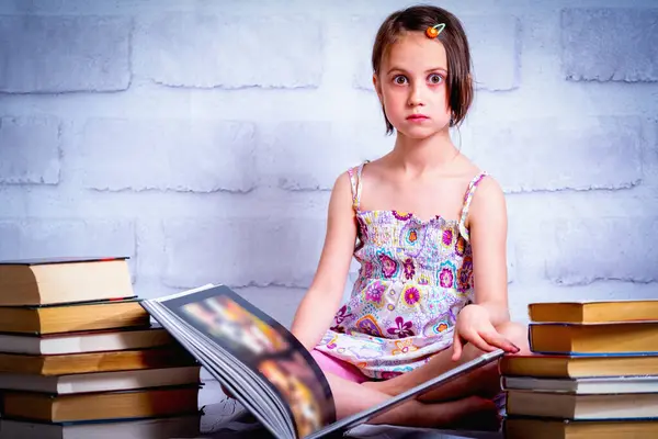 Knowledge and learning concept. Young cute child girl readin the book. Horizontal image.