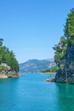 Oymapinar Gölü, Türkiye. Dağ gölü manzarası. Oymapinar barajının arkasındaki zümrüt su deposu. Manavgat bölgesindeki Yeşil Kanyon, Türkiye. Yüksek kalite fotoğraf. Dikey resim.