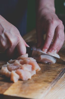 İtalyan pizzasını hazırlıyorum. Kapalı kapılar ardında pizzanın malzemelerini kendi elleriyle hazırlıyor. Tavuk filetosu kesiyor. Seçici odaklanma. Dikey resim.