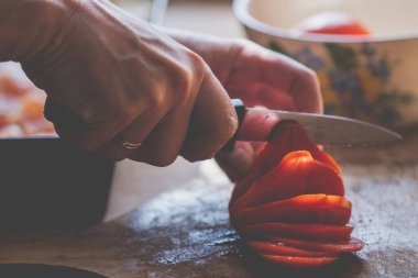 İtalyan ekmeği ve malzemeleri - parmesan, zeytinyağı, domates, baharat ve bitkiler. Şefin elleri pizzada domates dilimleri kesiyor. Kapat..