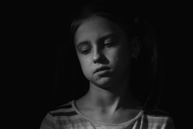 Ağlayan genç kız. Yalnızlık, acı, çocuk trajedisi. Siyah ve beyaz resim.