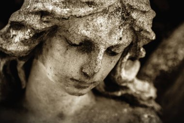 Yaprakların arka planında üzgün bir meleğin klasik görüntüsü 