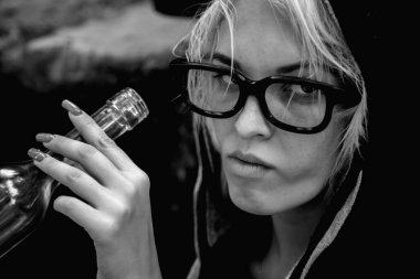 Yalnızlık, stres, alkolizm, alkol bağımlılığı. Votka ya da schnapps içen sarhoş kadın ya da kadın alkolik. Siyah beyaz görüntü..